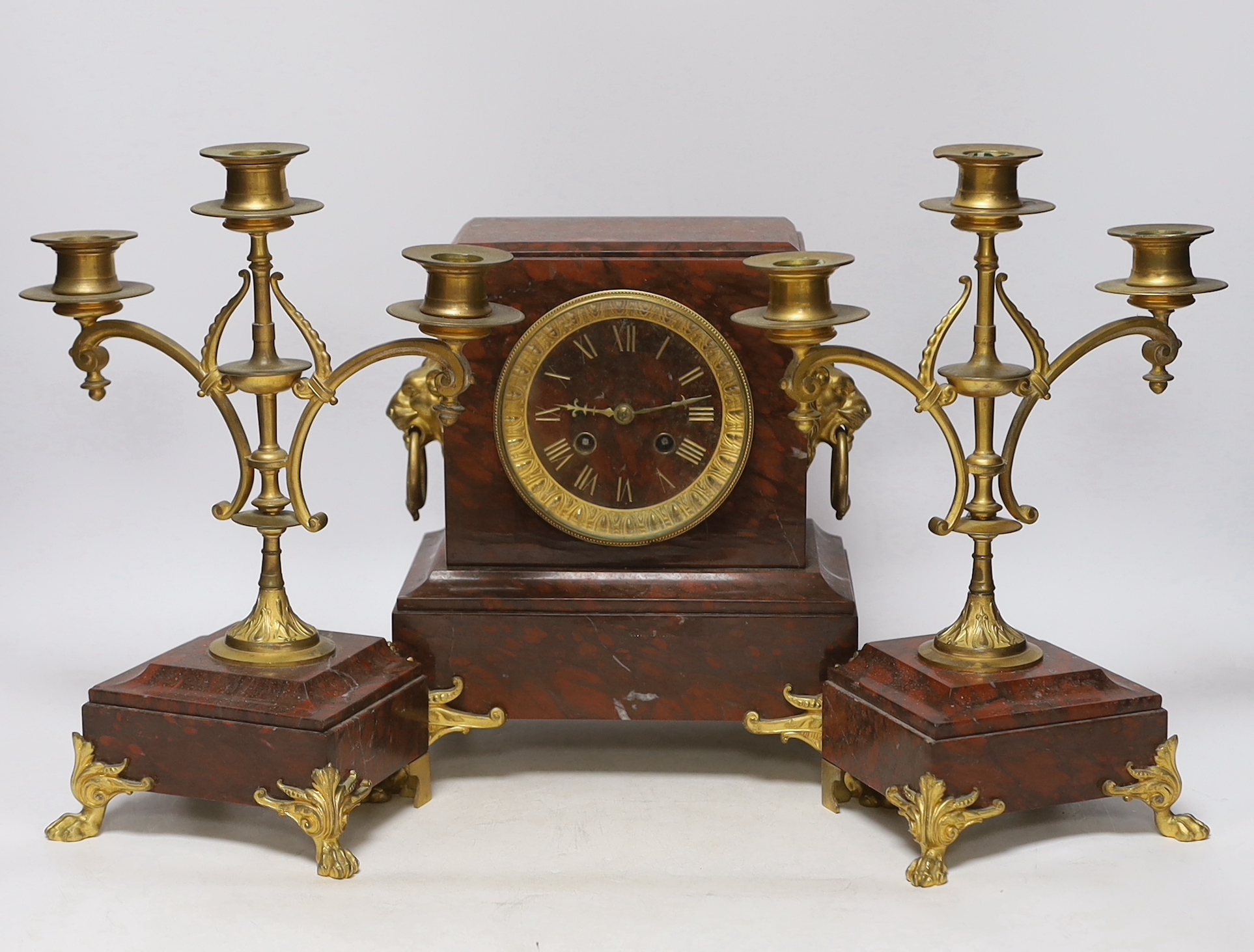 A late 19th century French rouge marble and ormolu clock garniture, 31cm